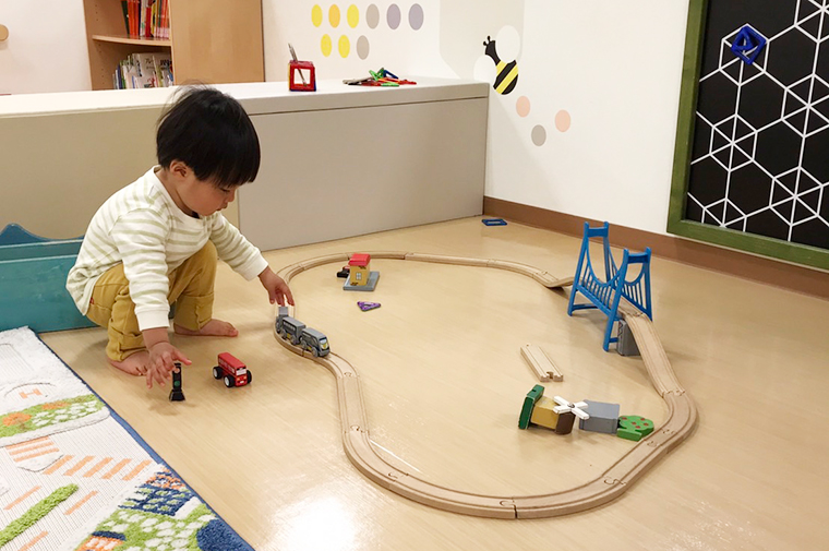 レールに電車を走らせ遊ぶ男の子